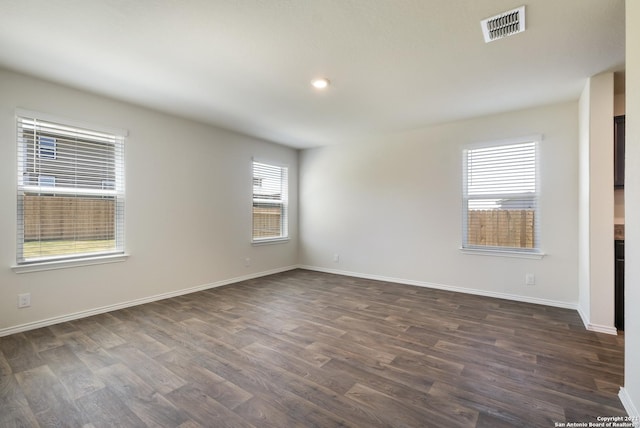 unfurnished room with a wealth of natural light and dark wood-type flooring