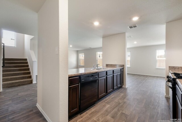 kitchen featuring gas stove, dark brown cabinetry, sink, hardwood / wood-style flooring, and dishwasher