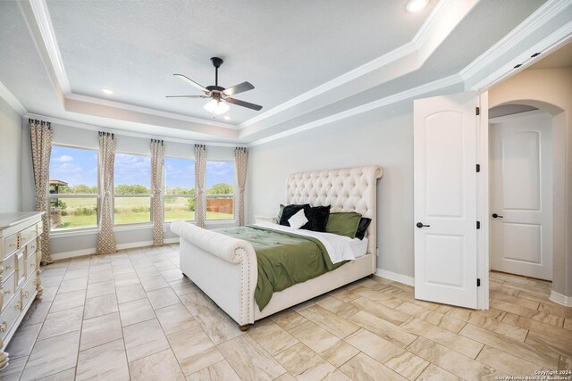 bedroom featuring crown molding, ceiling fan, and a tray ceiling