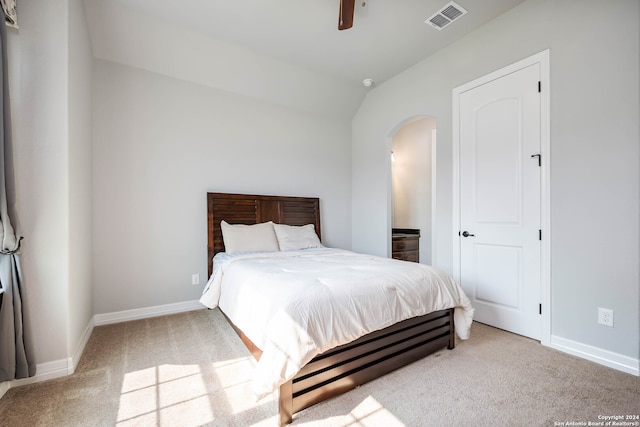 bedroom with ceiling fan, vaulted ceiling, and light colored carpet