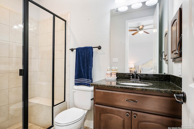 bathroom with an enclosed shower, large vanity, ceiling fan, and toilet