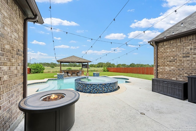 view of terrace with a gazebo, a fire pit, and a swimming pool with hot tub