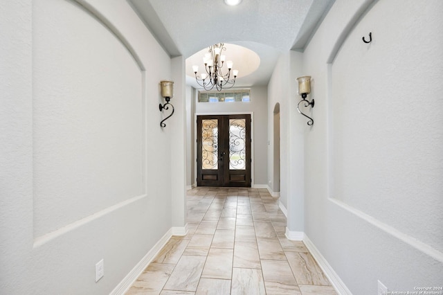 entryway with an inviting chandelier and french doors