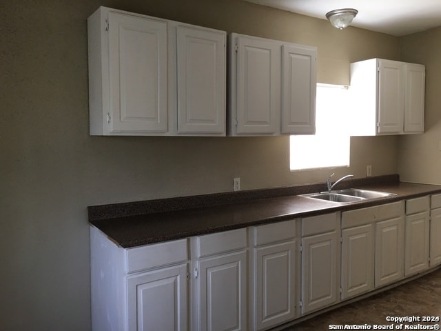 kitchen featuring white cabinetry and sink