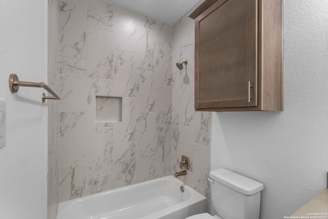 bathroom with toilet and tiled shower / bath combo