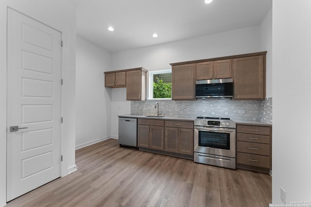 kitchen featuring light hardwood / wood-style floors, sink, backsplash, and stainless steel appliances