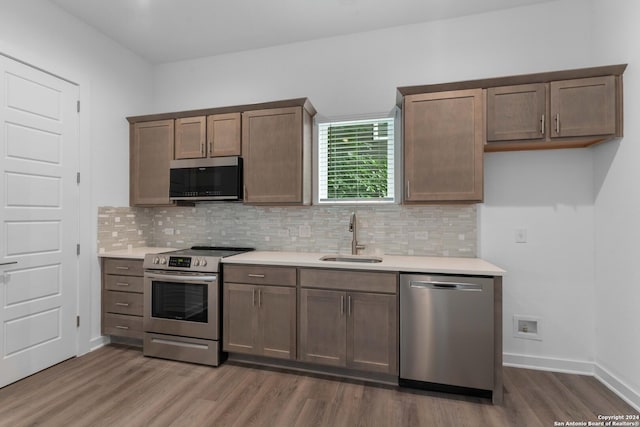 kitchen featuring sink, decorative backsplash, dark hardwood / wood-style floors, and appliances with stainless steel finishes