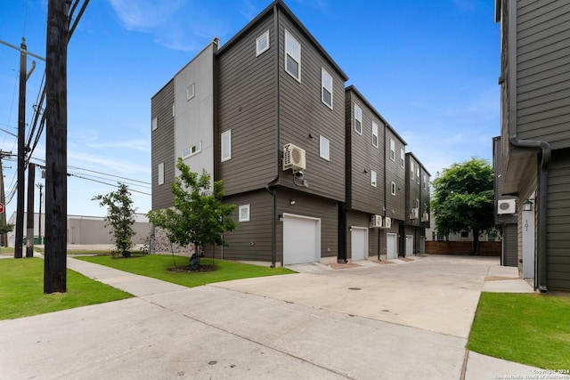 view of home's exterior with a lawn, a garage, and a wall unit AC