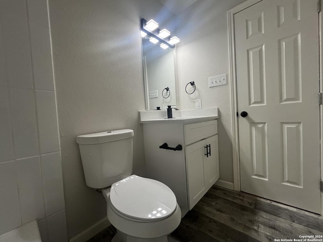 bathroom with toilet, vanity, and hardwood / wood-style flooring