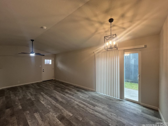 interior space featuring plenty of natural light, ceiling fan with notable chandelier, dark hardwood / wood-style floors, and vaulted ceiling