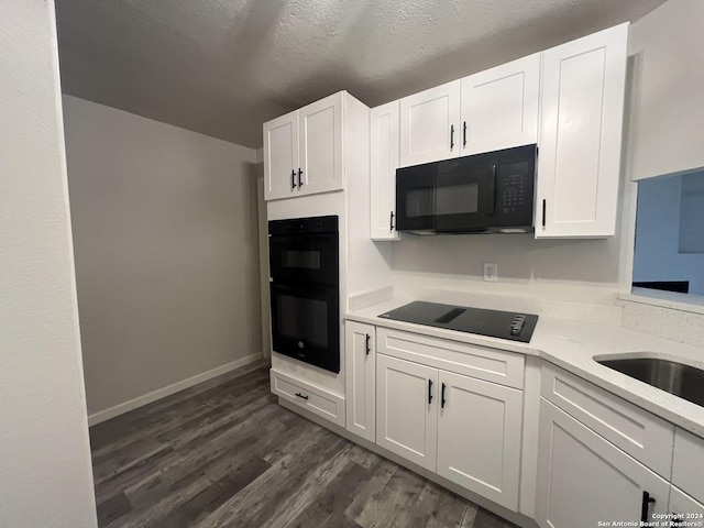 kitchen featuring dark hardwood / wood-style flooring, a textured ceiling, white cabinetry, and black appliances