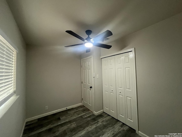 unfurnished bedroom featuring ceiling fan, dark hardwood / wood-style flooring, and a closet