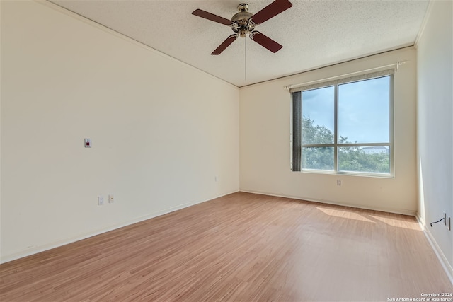 spare room featuring ceiling fan, a textured ceiling, and light wood-type flooring