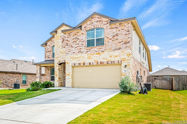 view of front of home featuring a garage, central AC, and a front lawn