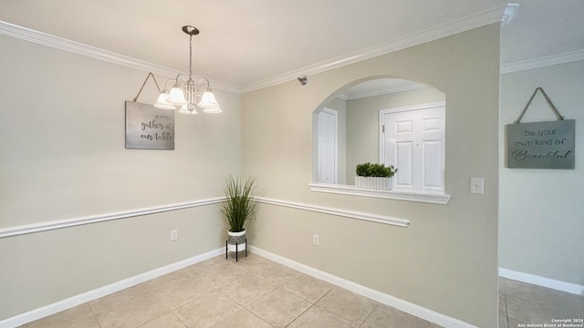 unfurnished room featuring crown molding, light tile patterned flooring, and an inviting chandelier