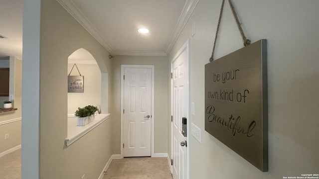 hallway with ornamental molding and light tile patterned flooring