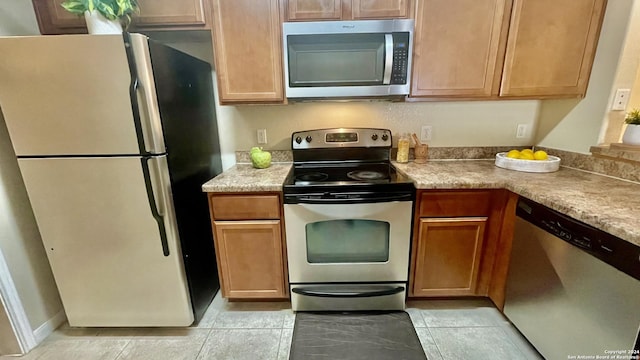 kitchen featuring light tile patterned floors and stainless steel appliances