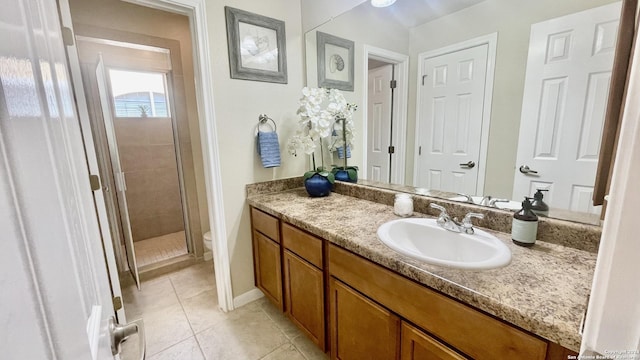 bathroom featuring toilet, vanity, tile patterned floors, and an enclosed shower