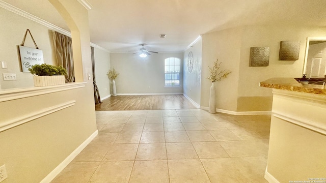 corridor with light hardwood / wood-style floors and ornamental molding