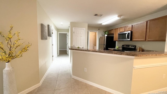 kitchen featuring kitchen peninsula, appliances with stainless steel finishes, and light tile patterned floors