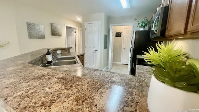 kitchen featuring kitchen peninsula, sink, and light tile patterned floors