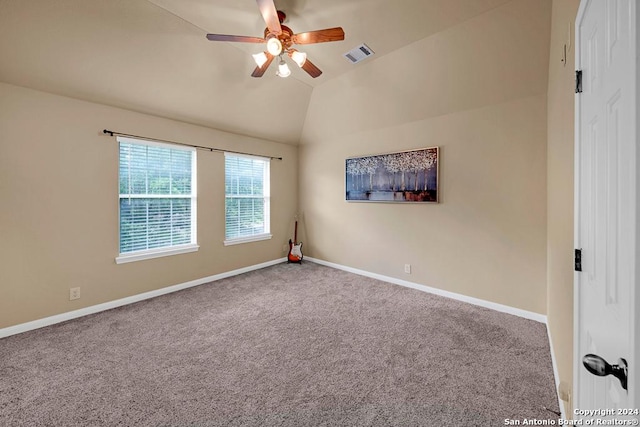 carpeted spare room featuring ceiling fan and vaulted ceiling