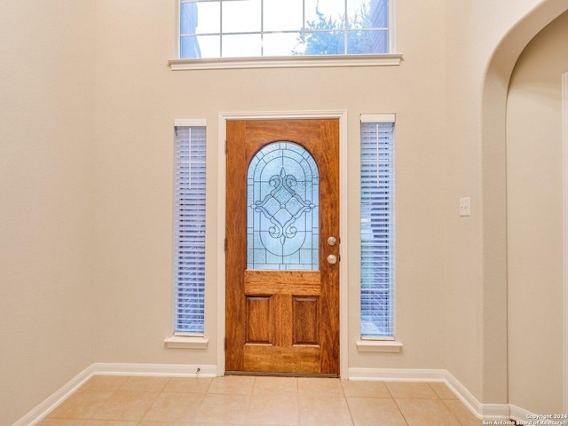 foyer entrance with light tile patterned flooring and a healthy amount of sunlight