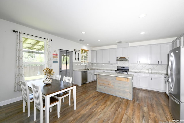 kitchen featuring a center island, sink, dark hardwood / wood-style floors, decorative backsplash, and appliances with stainless steel finishes