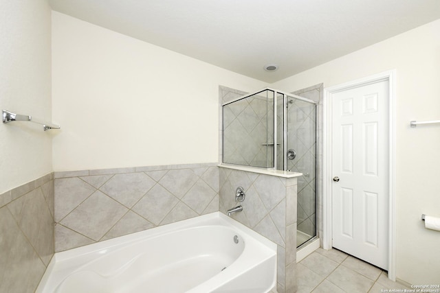 bathroom with tile patterned flooring and separate shower and tub