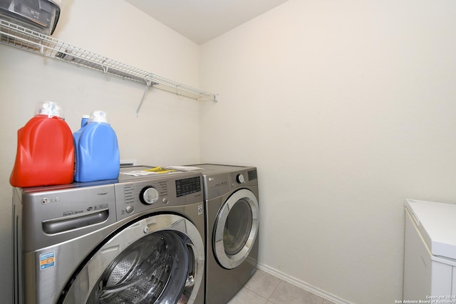 laundry area featuring washer and clothes dryer and light tile patterned floors