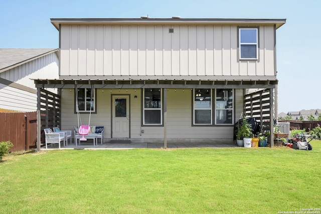 rear view of property with a lawn and a patio