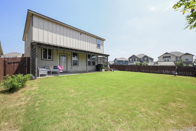 rear view of property featuring a lawn and a patio