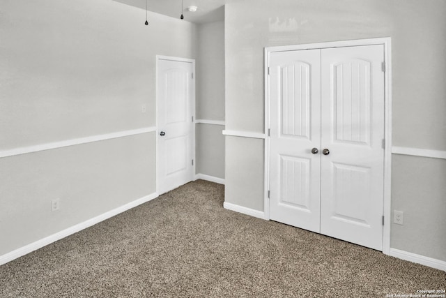 unfurnished bedroom featuring carpet flooring and a closet