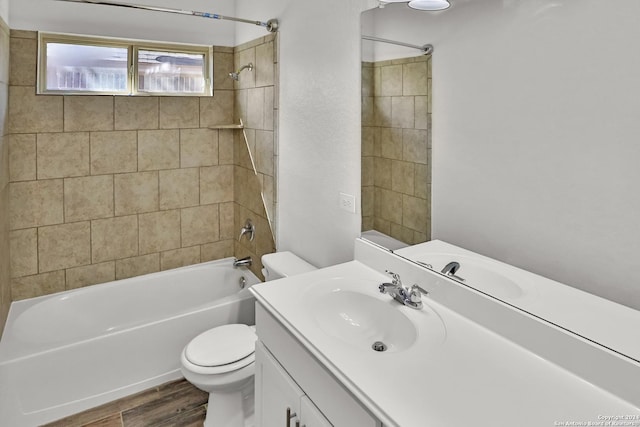 full bathroom with toilet, vanity, wood-type flooring, and tiled shower / bath