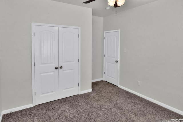 unfurnished bedroom with a closet, dark carpet, and ceiling fan