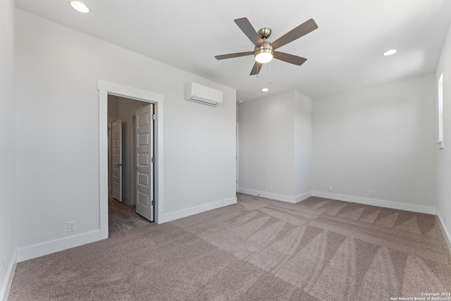 spare room featuring ceiling fan, light colored carpet, and a wall mounted air conditioner