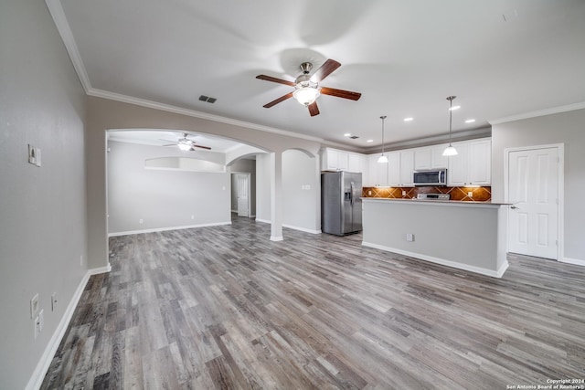 unfurnished living room with ornamental molding, ceiling fan, and light hardwood / wood-style flooring