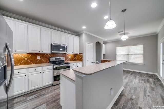 kitchen with pendant lighting, white cabinetry, an island with sink, backsplash, and stainless steel appliances