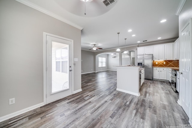 kitchen featuring hanging light fixtures, a center island with sink, appliances with stainless steel finishes, ceiling fan, and white cabinets