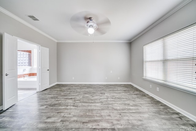 empty room featuring ornamental molding, a wealth of natural light, and light hardwood / wood-style floors