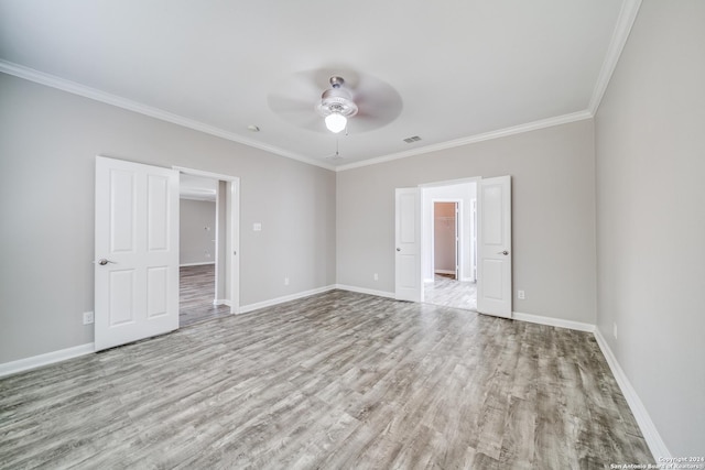 empty room featuring ceiling fan, ornamental molding, and light wood-type flooring