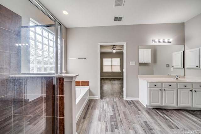 bathroom featuring ceiling fan, vanity, a bath, and hardwood / wood-style floors