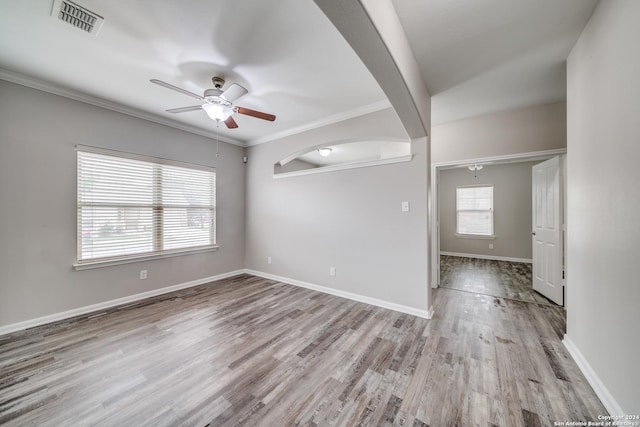 spare room with ornamental molding, plenty of natural light, light hardwood / wood-style floors, and ceiling fan