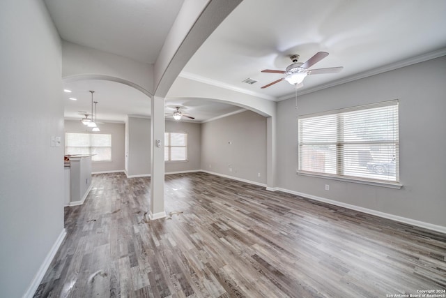 unfurnished living room featuring hardwood / wood-style flooring, crown molding, and ceiling fan