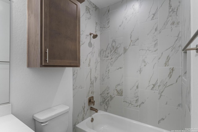 bathroom with toilet and tiled shower / bath