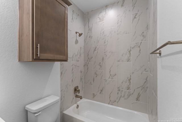 bathroom featuring toilet and tiled shower / bath combo