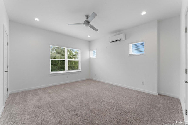 empty room with light colored carpet, plenty of natural light, a wall mounted AC, and ceiling fan