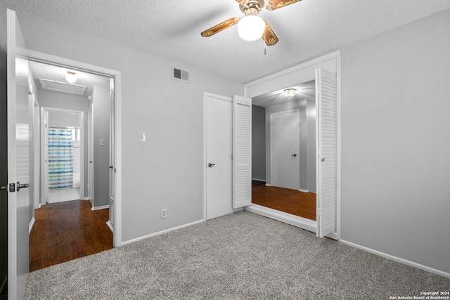 unfurnished bedroom with carpet flooring, a textured ceiling, a closet, and ceiling fan