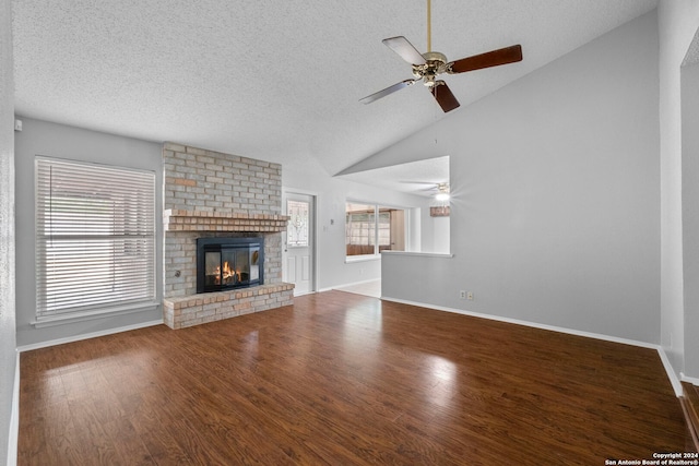 unfurnished living room featuring ceiling fan, high vaulted ceiling, hardwood / wood-style floors, a textured ceiling, and a fireplace