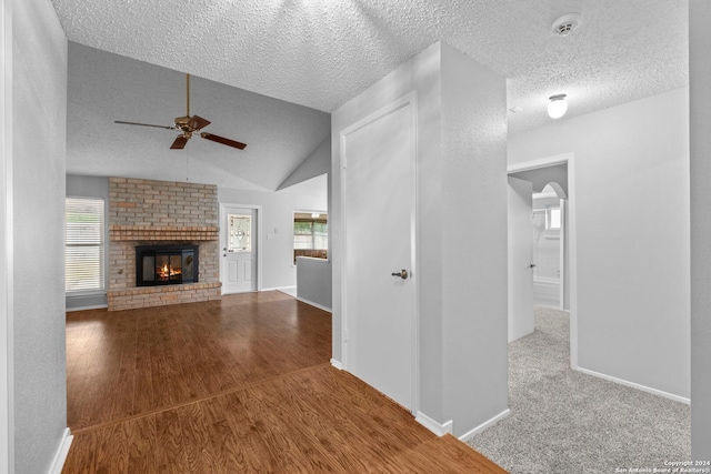 unfurnished living room featuring a wealth of natural light, wood-type flooring, and lofted ceiling